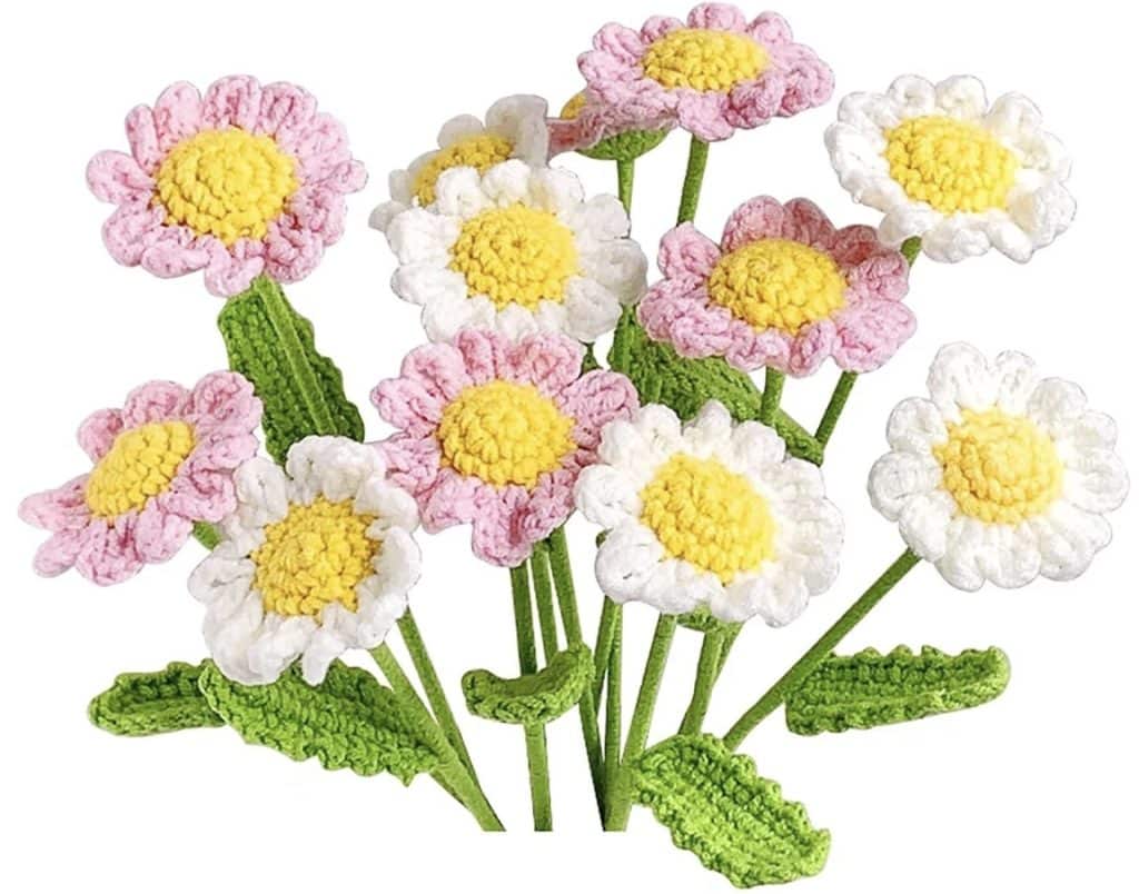 A bouquet of crocheted flowers with yellow centers, pink and white petals, and green stems and leaves—these daisy-inspired blooms are among my favorite flower crafts.